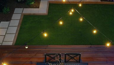 Chic Backyard Design With Dark Dining Set, Firepit, And String Lights